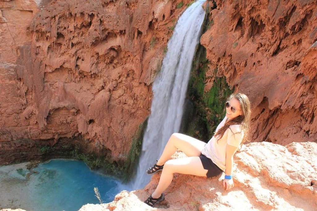 woman sitting by waterfall in arizona