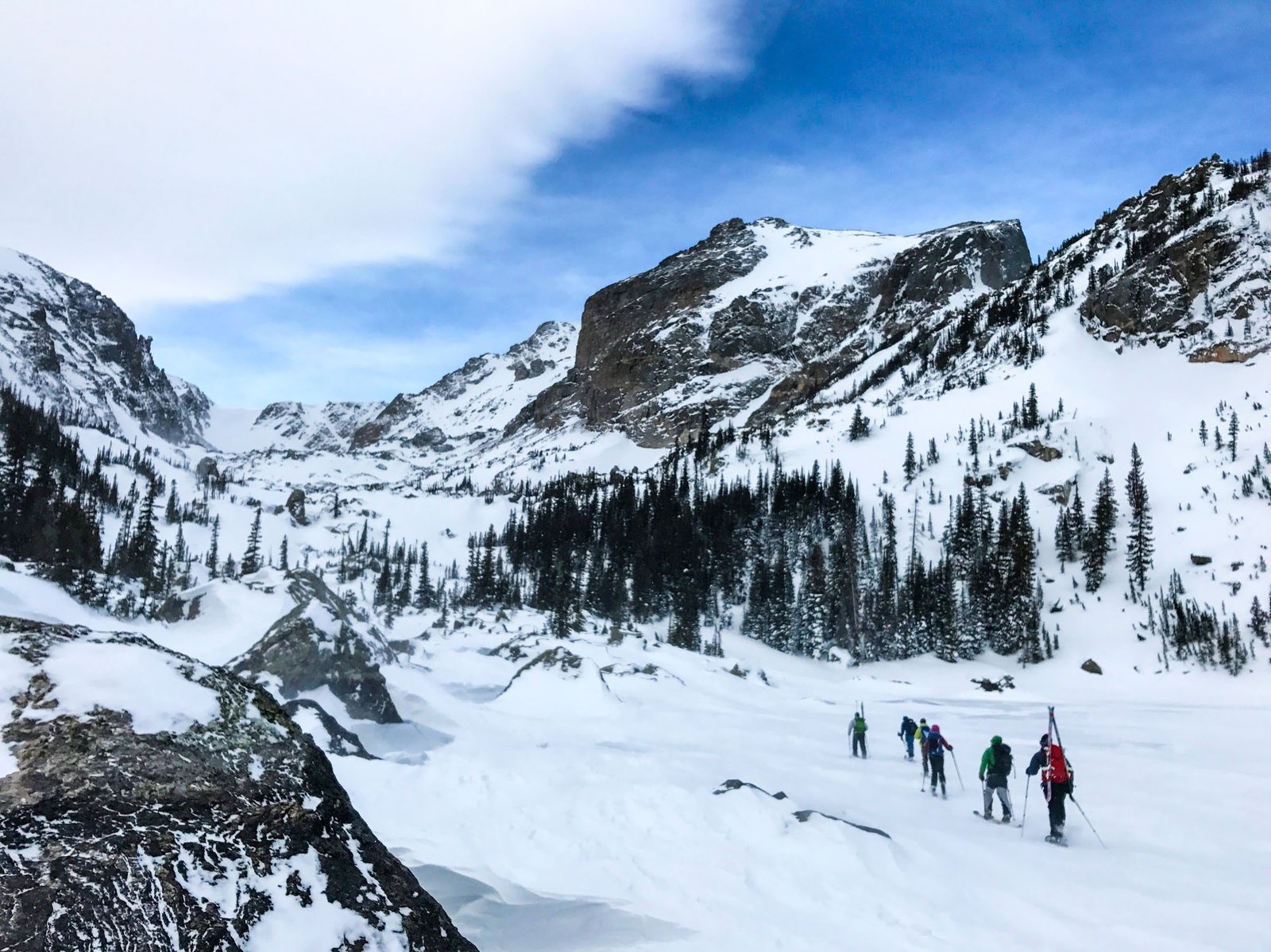 Photo of skiers walking through path covered in snow