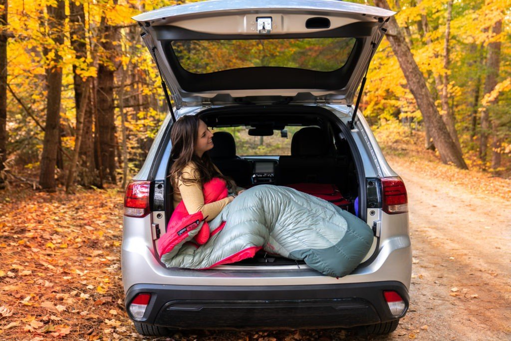 woman in a sleeping bag in a suv
