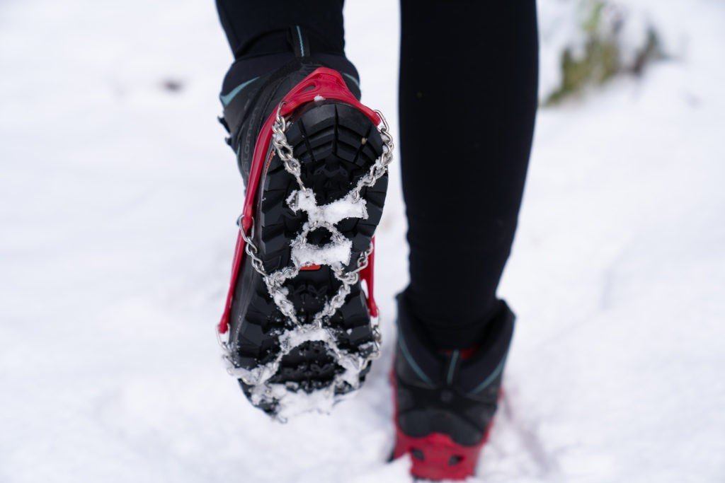 woman hiking in the snow with microspikes