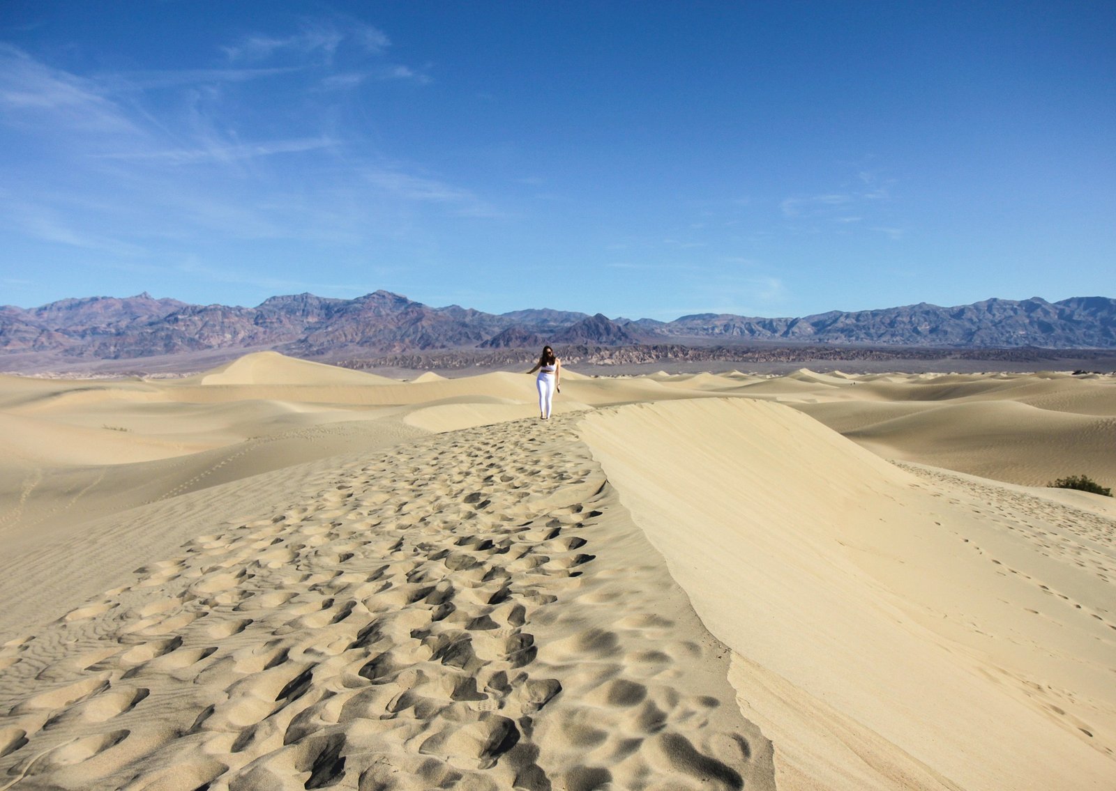 woman walking over a sand dune in Death Valley National Park 2