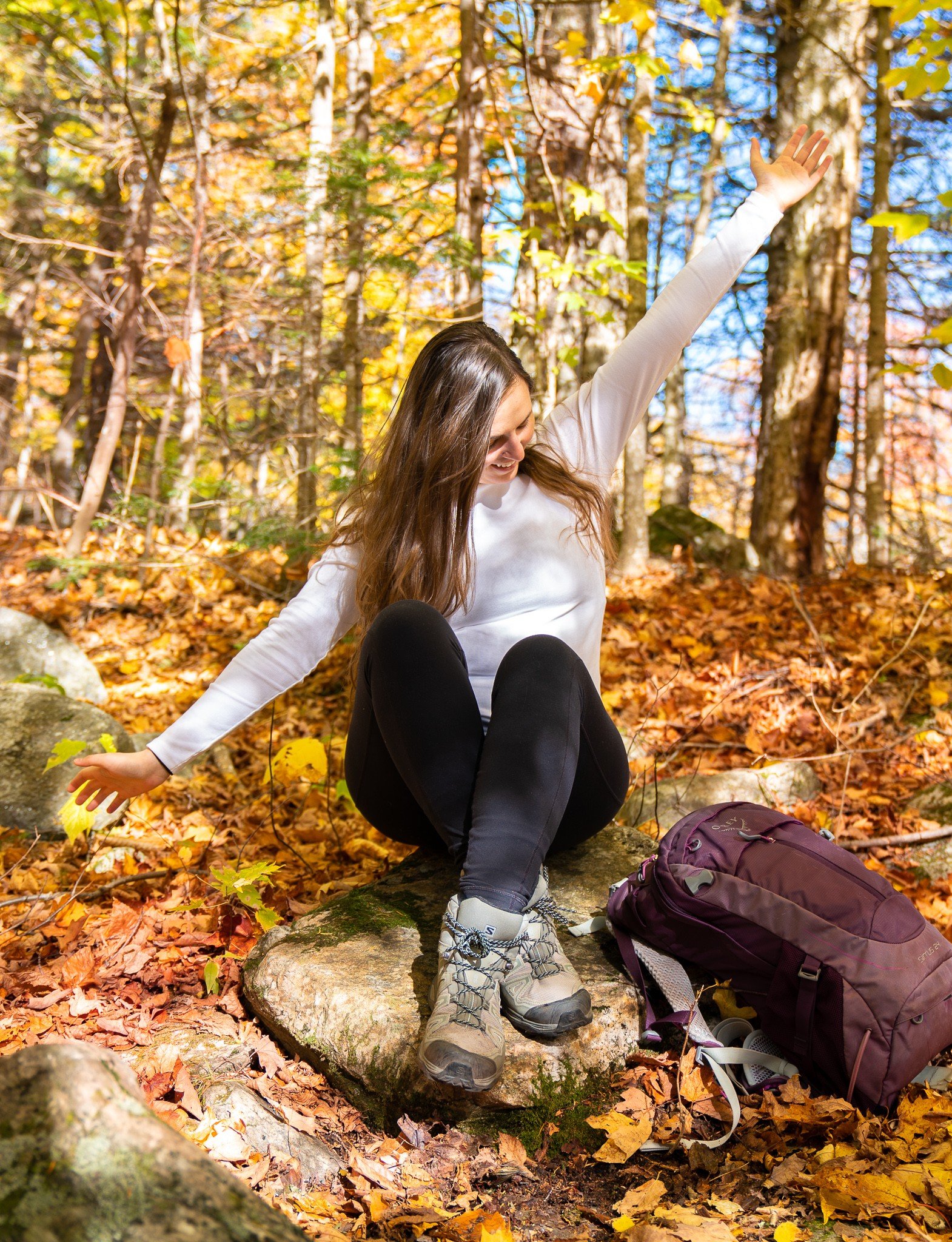 woman sitting among fall leaves